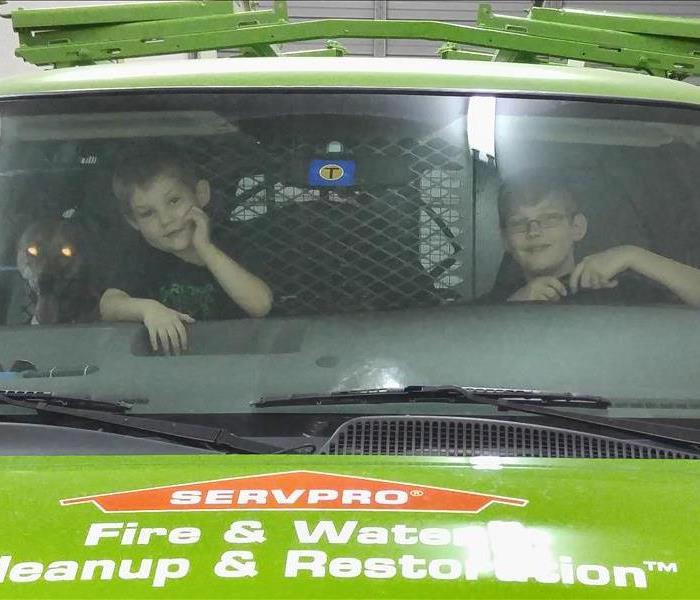2 children and a dog in a SERVPRO van.