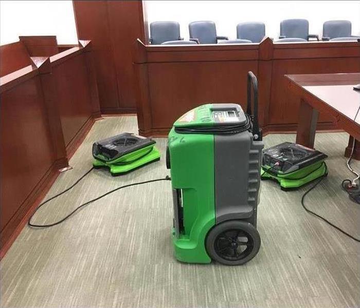 Two air movers and one dehumidifier placed in a court room.