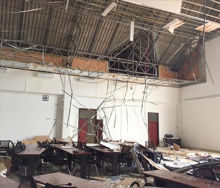 Ceiling collapsed, debris on floor, desks damaged