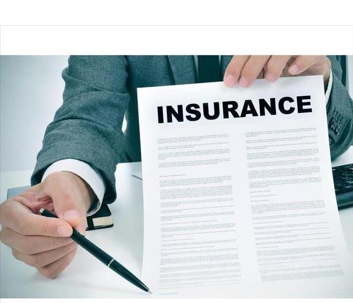 Man holding an insurance form with a pen on the other hand