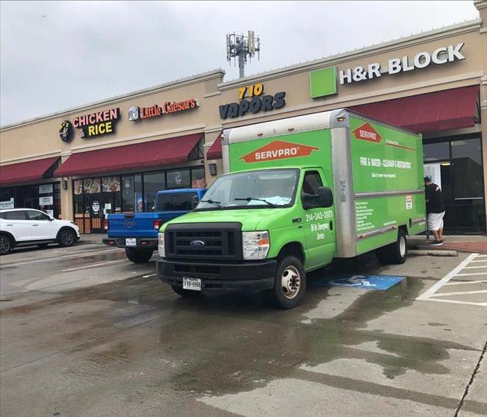 Green SERVPRO van parked outside a business.